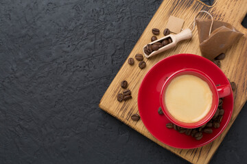 Red cup of coffee on concrete background, top view