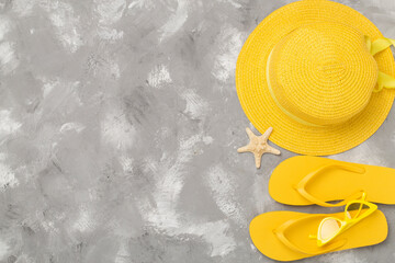 Flat lay with yellow summer outfit on concrete background. Vacation concept