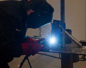 Competitions among welders. A man in a protective mask is welding.