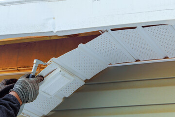 Master of house repairs damaged fascia trim during remodeling home