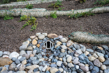 New installation of storm water flood management, round outflow pipe leading to a flow of river...
