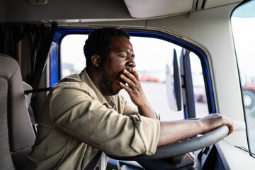 Tired truck driver feeling sleepy and yawning while driving.