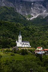 Fototapeta premium San Fermin Church immersed in the green of the Slovenian mountains a few steps from Caporetto. It remains a precious gem of Christianity and faith to be admired, makes the view of the mountain unique.