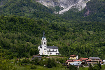 Fototapeta premium San Fermin Church immersed in the green of the Slovenian mountains a few steps from Caporetto. It remains a precious gem of Christianity and faith to be admired, makes the view of the mountain unique.