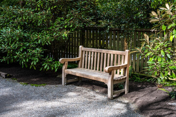 Classic wood seat bench with backrest outside in a woodland garden, peaceful place for rest and...