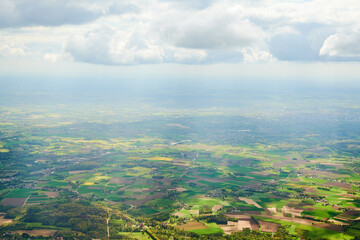 Flying over European country. Aerial view of European countryside and agricultural lands from an airplane window.