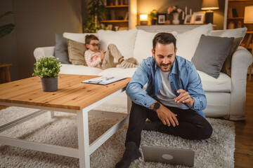 Father work from home use laptop with son at background