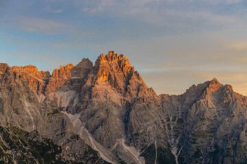 Naklejka premium Dolomiti Alps beautiful mountain landscape. Rocky tower alpine summits in the Dolomites. Summer mountain scenic view on the hiking trekking path in the green mountain valley and blue sky with clouds