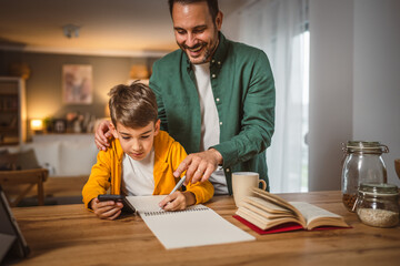 Father with cup help son who copy notes from mobile phone at home