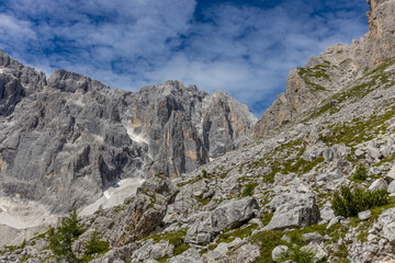 Dolomiti Alps beautiful mountain landscape. Rocky tower alpine summits in the Dolomites. Summer mountain scenic view on the hiking trekking path in the green mountain valley and blue sky with clouds