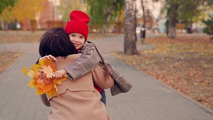 Child, girl runs to mom, hugs her in autumn Park. Carefree childhood, joyful embrace of child of...