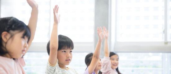 授業を受ける小学生 ハイと手を挙げ挙手をするバナー