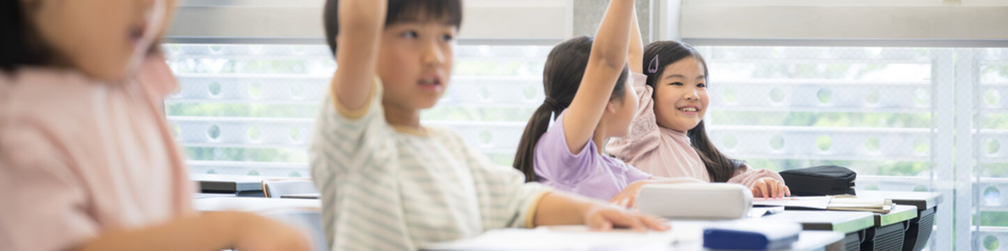 Elementary school students in class Banner raising hands and raising hands
