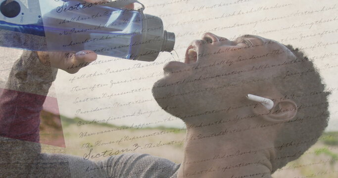 Image of american flag over african american man drinking water in mountains - Powered by Adobe