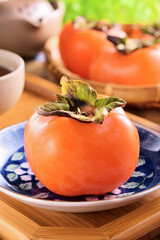 Delicious ripe persimmon fruit on wooden table.  