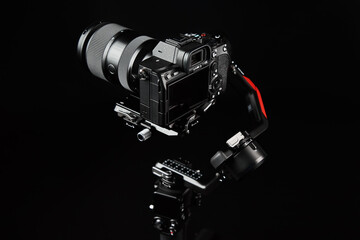 Camera mounted on gimbal on dark background. Camera stabilization technology. Electronic steadicam....