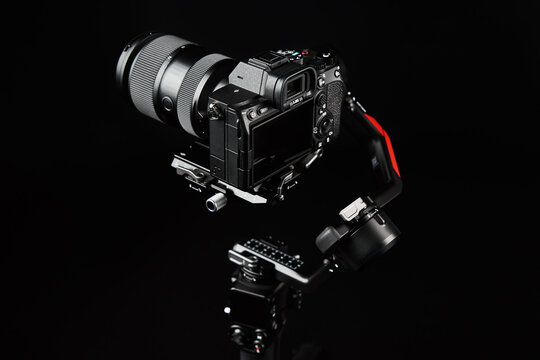 Camera mounted on gimbal on dark background. Camera stabilization technology. Electronic steadicam. Video shooting equipment