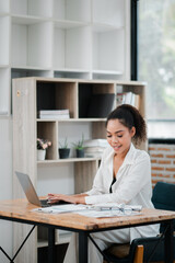 Young Professional Woman Working on Laptop in Modern Office with Natural Light and Minimalist Decor