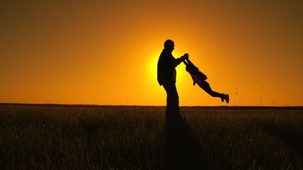 Happy family father child play, park sun. Dad twists his daughter holding hands. Fun family...