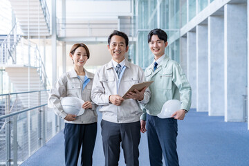 カメラ目線の作業着を着た男女3人