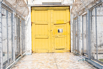 yellow wooden door used to imprison prisoners in the past