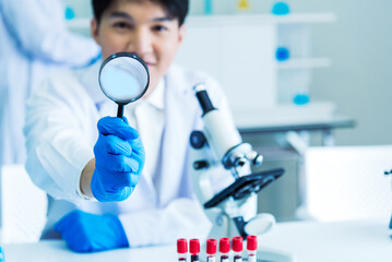 Scientist man look into Microscope research in science laboratory. Asian scientist look at...