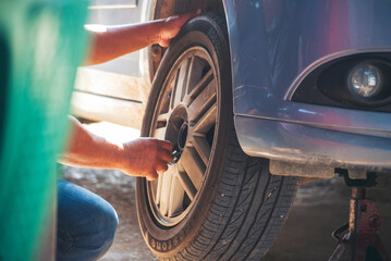 Mechanic man hands checking car tires outdoor on site service auto garage for automotive mobile center services. Technician workshop repair checking tyres car motor vehicles service mechanical hands