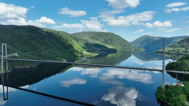 Osteroy bridge in western Norway in beautiful weather with sky reflection in sea, aerial