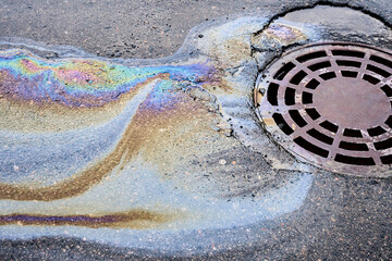 Fuel and lubricants from a vehicle mishap have created a hazardous puddle on the blacktop, flowing...