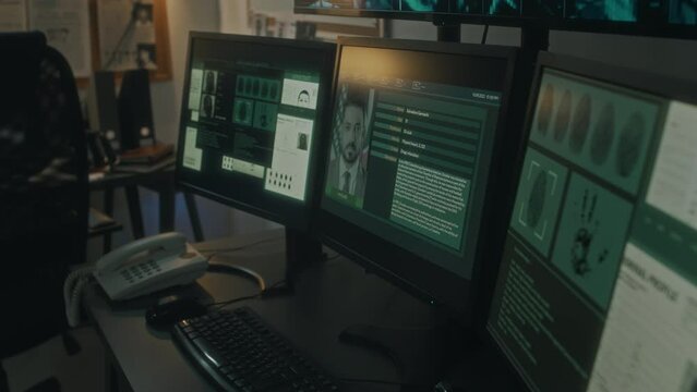 Close-up tilt down shot of screen with orbital surveillance camera footage, computer screens with suspect photo, finger and palm prints, crime map with criminal profiles, at bureau of investigations