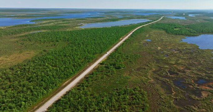 Drone tracking a van driving in arctic nature, summer day in Kaldoaivi, Finland
