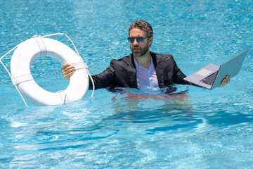 Helping business. Business man in suit hold laptop and help lifebuoy in swim pool. Rescue help...