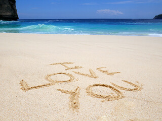 Love Symbol On a Sand Of Beach With Soft Blue Wave On Background