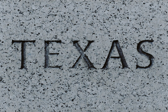 The words Texas engraved in granite stone