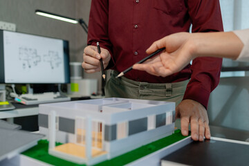 two architects are discussing about new project of the biggest housing estate company who hire their architecture company to design the best  construction