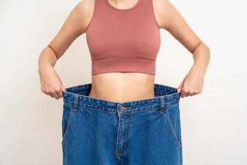 Close up thin slender abdomen waist woman wearing old big jean after her success weight loss diet...