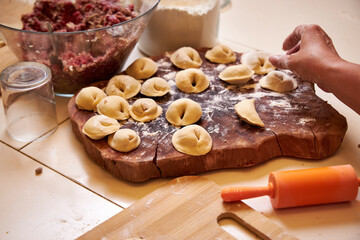 family at the table in the kitchen making dumplings