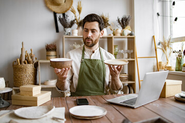 Professional seller checking for no damages on bowl and plate that holding in hands. Attractive...