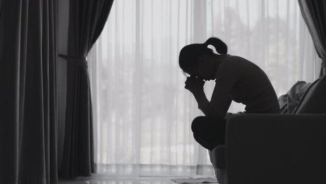 Silhouette of a woman who is stressed and suffering from depression alone. Anxiety young woman Despair and stress. Lonely and unhappy female are social victims. loneliness youth in home.