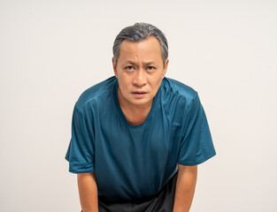 Senior sporty person in sports uniform. Old man senior tired he felt a pain in his chest held his hand and squeezed it. Mature Heart attack that needed treatment.