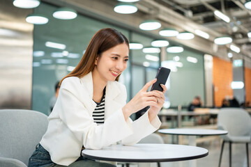 Young asian business woman with smartphone working in the office. Start up freelancer people posing while using mobile cell phone working in the modern office. Lifestyle business female.