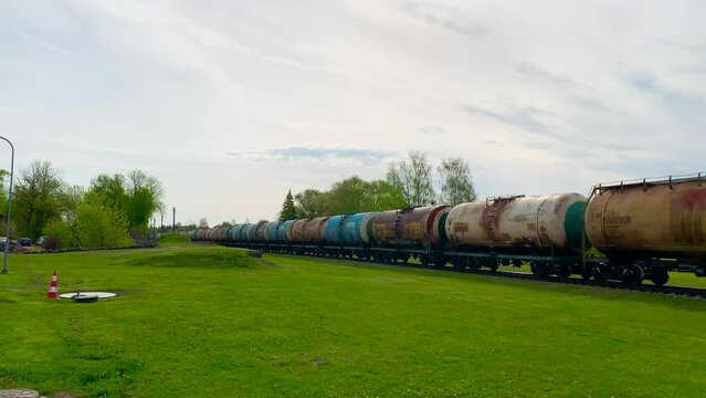 Static shot of long line of freight train cisterns transport diesel fuel, Latvia