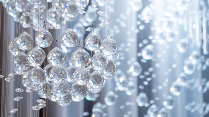 Close up of a luxurious white crystal chandelier. Glamour glass ball details and interior...