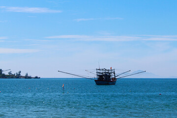 Photograph of traditional Asian fishing boats floating in the sea near Da Nang, Vietnam. Captures...