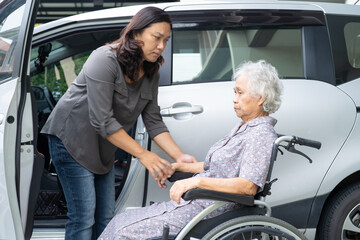 Caregiver help and support asian elderly woman sitting on wheelchair prepare get to her car to...