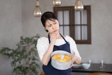 お菓子作りがうまくいかず考える若い女性