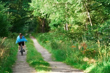 Obraz premium Young woman biking on country road