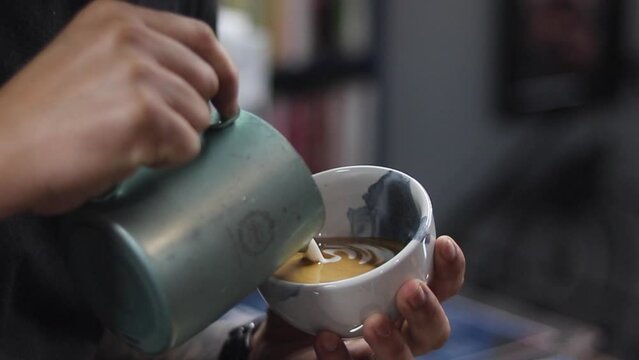 barista making a cup of latte art