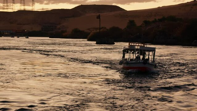 Drone following a boat cruising sailing the Nile River in Egypt at sunset