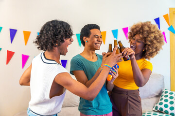 Multi-ethnic friends toasting with beer during party at home
